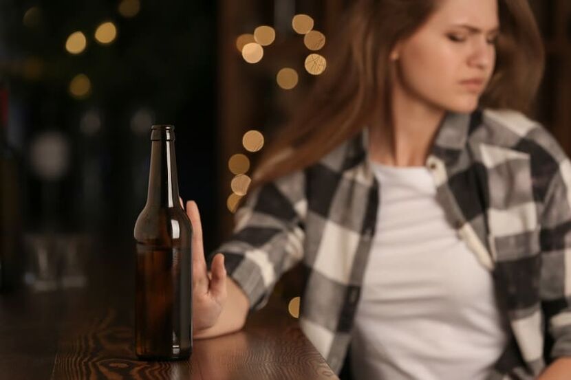 de vrouw wendt zich tot alcohol